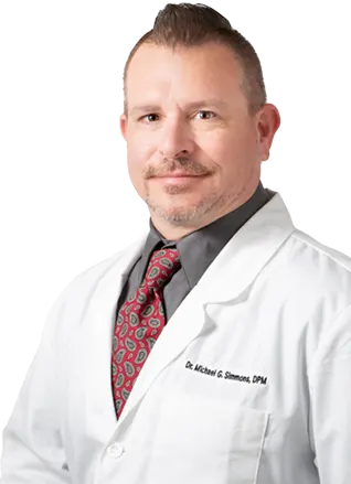 Professional podiatrist in a white coat and red patterned tie.