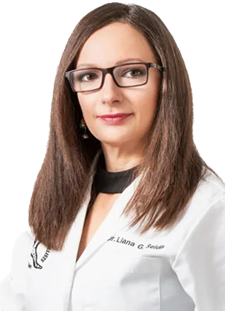Professional woman with glasses wearing a white lab coat.
